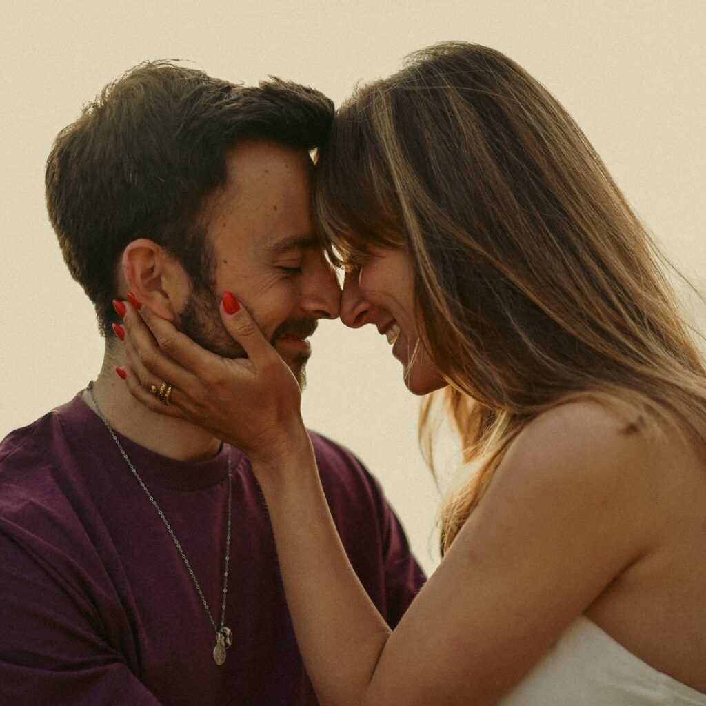 Couple Sitting in front of each other with closed eyes connection through touch.